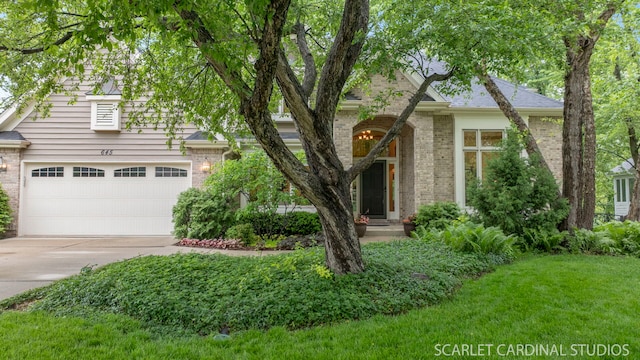 645 Rosewood Dr, West Chicago, IL 60185 - view of property hidden behind natural elements featuring concrete driveway, brick siding, and a front lawn