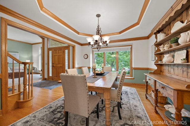 645 Rosewood Dr, West Chicago, IL 60185 - dining space featuring crown molding, a chandelier, a raised ceiling, stairway, and light wood finished floors