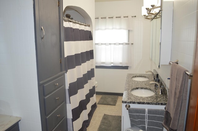 bathroom featuring double vanity, tile walls, and a shower with curtain