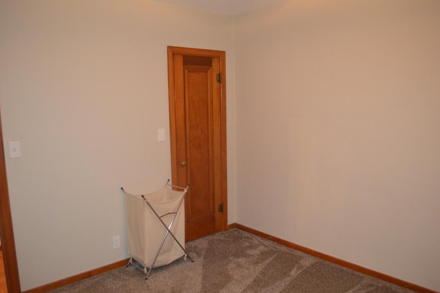 empty room with baseboards and dark carpet