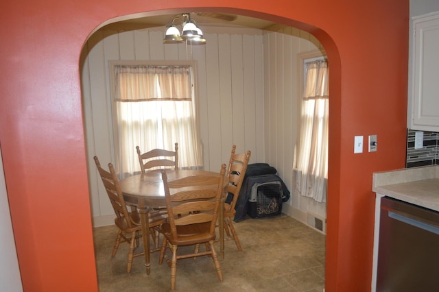 dining area featuring arched walkways and healthy amount of natural light