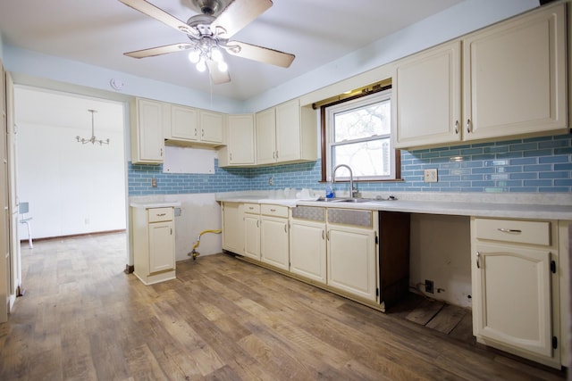 2214 N Bur Oak Ct, Bonfield, IL 60913 - kitchen featuring wood finished floors, cream cabinetry, a sink, ceiling fan with notable chandelier, and backsplash