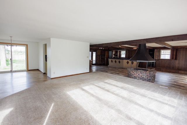 2214 N Bur Oak Ct, Bonfield, IL 60913 - unfurnished living room featuring wooden walls, carpet, baseboards, wood finished floors, and beamed ceiling