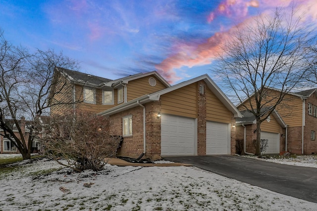 17247 Lakebrook Dr, Orland Park, IL 60467 - view of snowy exterior with a garage, driveway, and brick siding