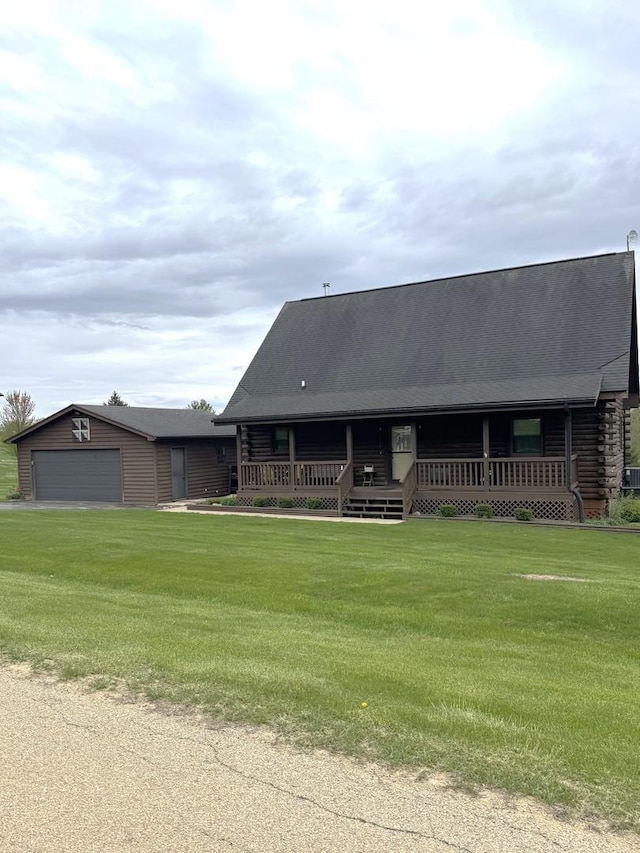 log cabin with an attached garage, an outbuilding, log siding, and a front lawn