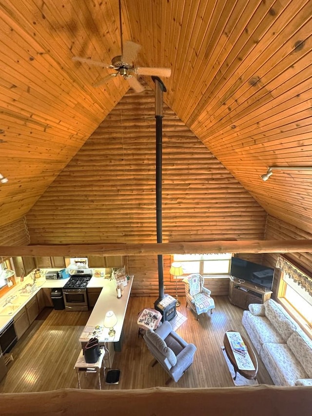 interior space featuring wood-type flooring, rustic walls, high vaulted ceiling, wooden ceiling, and a ceiling fan