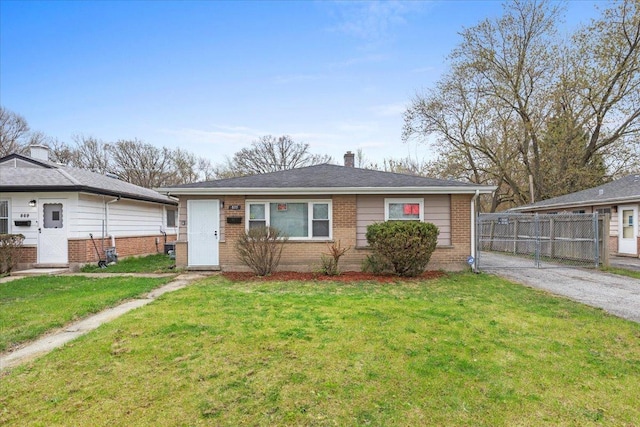 877 163rd St, Calumet City, IL 60409 - view of front of property with a chimney, a front yard, brick siding, fence, and aphalt driveway