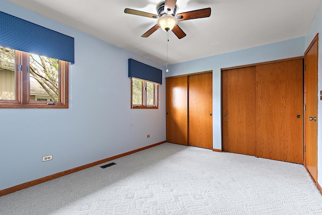 17130 Inverness Dr, Tinley Park, IL 60487 - unfurnished bedroom featuring visible vents, multiple closets, baseboards, ceiling fan, and light colored carpet