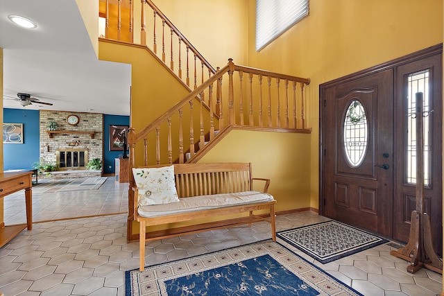 17130 Inverness Dr, Tinley Park, IL 60487 - tiled foyer with a brick fireplace, a ceiling fan, stairway, and a towering ceiling