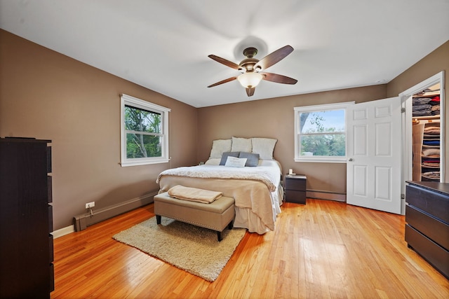227 Abbott Pl, Tower Lakes, IL 60010 - bedroom featuring a baseboard radiator, multiple windows, light wood-style flooring, and ceiling fan