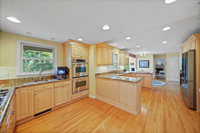 227 Abbott Pl, Tower Lakes, IL 60010 - kitchen with appliances with stainless steel finishes, a peninsula, light brown cabinetry, a sink, and light wood-style floors