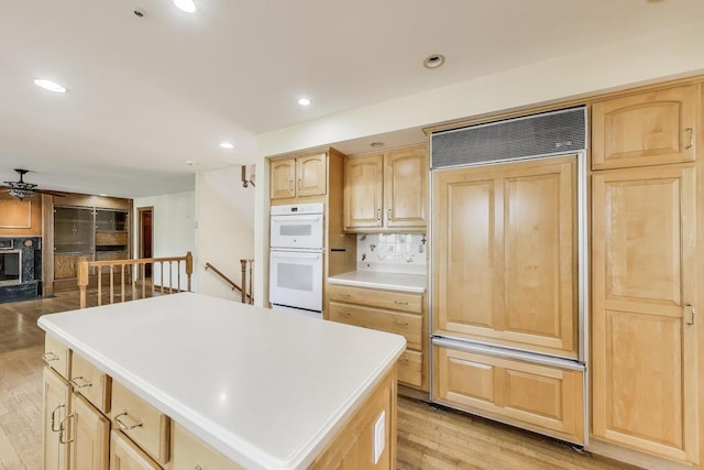 2125 Harrow Gate Dr, Inverness, IL 60010 - kitchen featuring decorative backsplash, light brown cabinets, a center island, light wood-type flooring, and paneled fridge