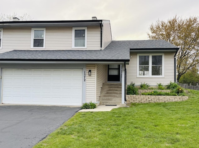 1572 Brandywyn Ln, Buffalo Grove, IL 60089 - split level home with an attached garage, a front lawn, aphalt driveway, and fence