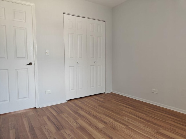 1572 Brandywyn Ln, Buffalo Grove, IL 60089 - unfurnished bedroom with baseboards, wood finished floors, and a closet