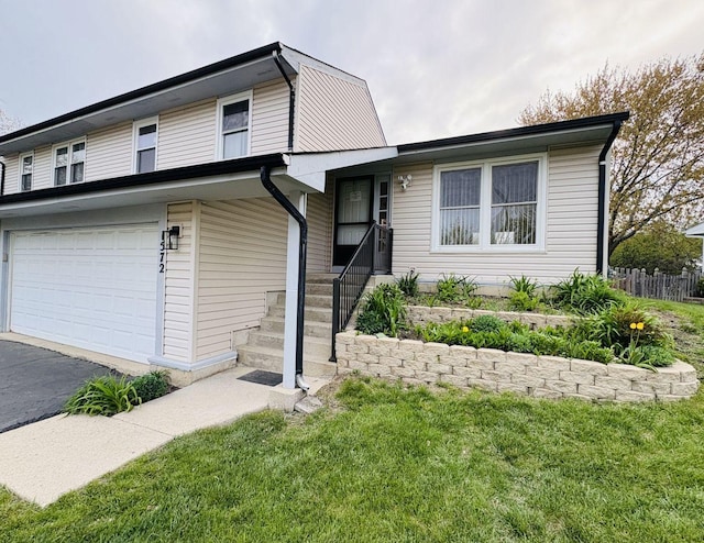 1572 Brandywyn Ln, Buffalo Grove, IL 60089 - split level home featuring fence, an attached garage, driveway, and a front lawn
