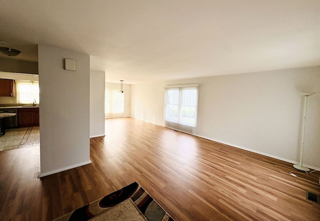 1572 Brandywyn Ln, Buffalo Grove, IL 60089 - unfurnished living room with plenty of natural light, a sink, baseboards, and wood finished floors