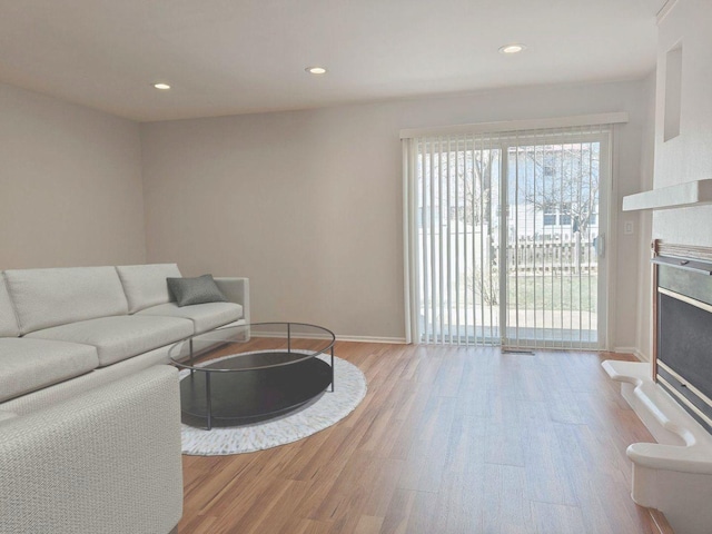 1572 Brandywyn Ln, Buffalo Grove, IL 60089 - living area featuring baseboards, a fireplace with raised hearth, recessed lighting, and wood finished floors