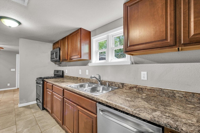 902 N Lincoln Ave, Urbana, IL 61801 - kitchen featuring appliances with stainless steel finishes, a sink, light tile patterned flooring, dark countertops, and brown cabinetry