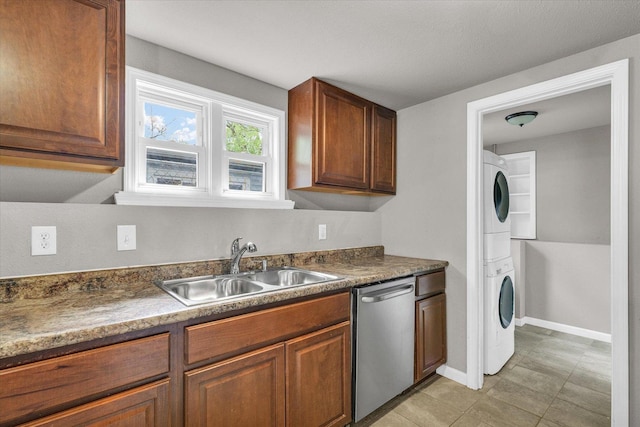 902 N Lincoln Ave, Urbana, IL 61801 - kitchen featuring stainless steel dishwasher, estacked washer and dryer, a sink, dark countertops, and baseboards