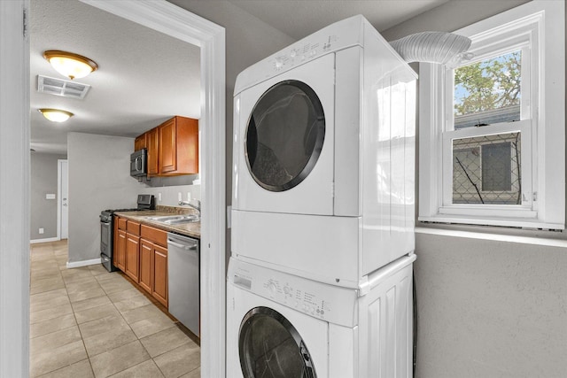 902 N Lincoln Ave, Urbana, IL 61801 - washroom featuring stacked washer / drying machine, light tile patterned flooring, and baseboards