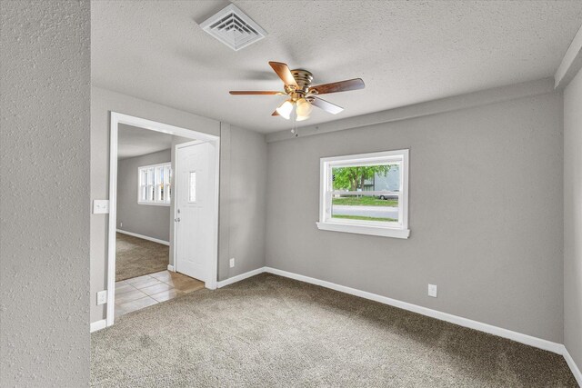 902 N Lincoln Ave, Urbana, IL 61801 - carpeted spare room with a ceiling fan, healthy amount of natural light, baseboards, and a textured ceiling