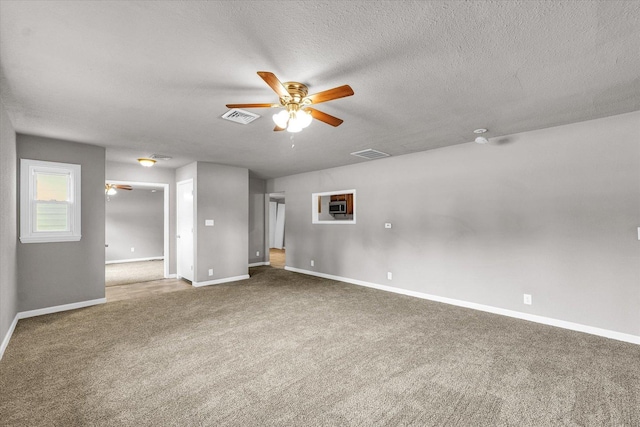 902 N Lincoln Ave, Urbana, IL 61801 - unfurnished living room featuring ceiling fan, carpet flooring, baseboards, and a textured ceiling