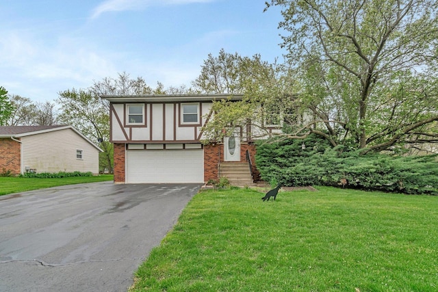 split foyer home with brick siding, an attached garage, a front yard, and aphalt driveway