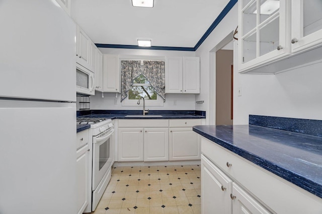 kitchen featuring a sink, white cabinets, and white appliances