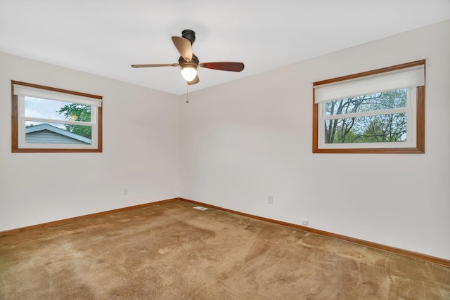 spare room with carpet floors, baseboards, and ceiling fan