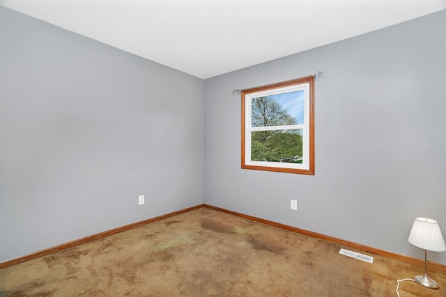 empty room with baseboards, carpet flooring, and visible vents