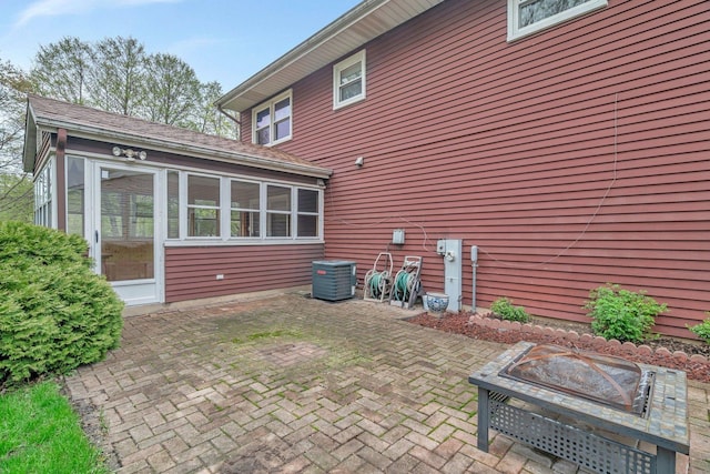 back of property featuring a sunroom, central AC, and a patio area