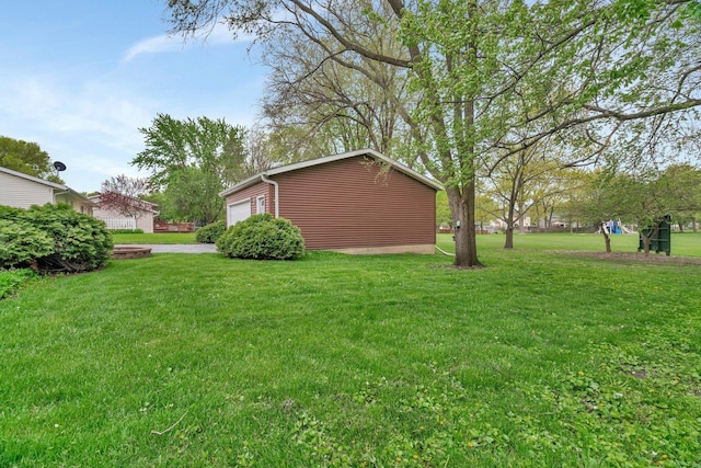 view of yard with a garage and an outbuilding