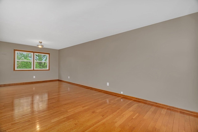 empty room with baseboards and light wood finished floors