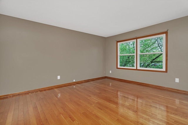 spare room with light wood-style floors and baseboards