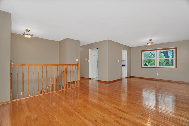 spare room with light wood-style floors and baseboards