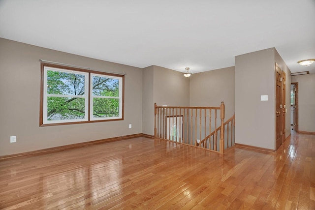spare room with baseboards and light wood-style flooring