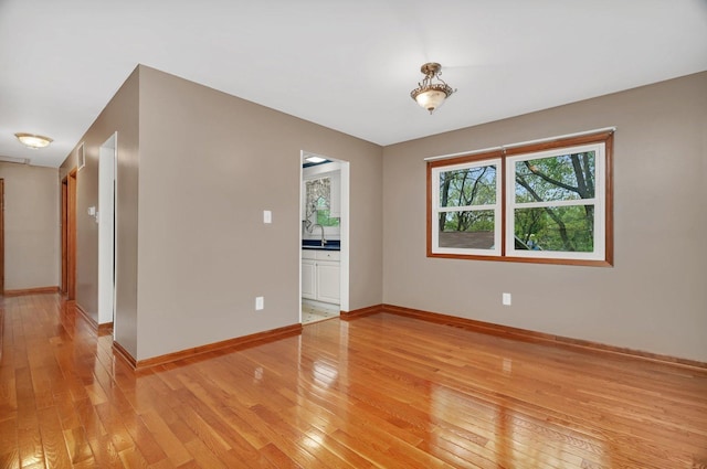 unfurnished room with baseboards and light wood finished floors