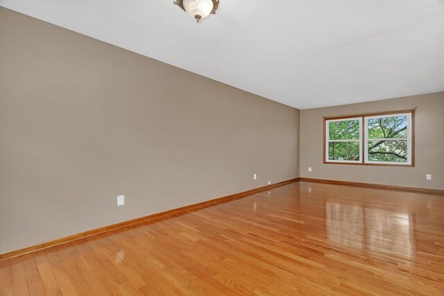 unfurnished room featuring baseboards and light wood-style flooring