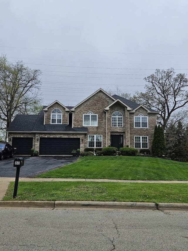 view of front facade featuring a front yard and aphalt driveway