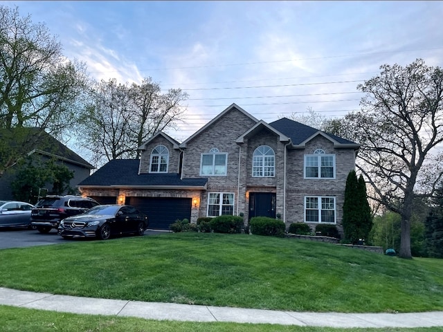 80 Chestnut Ct, Elgin, IL 60120 - traditional-style house featuring a front lawn, brick siding, driveway, and an attached garage