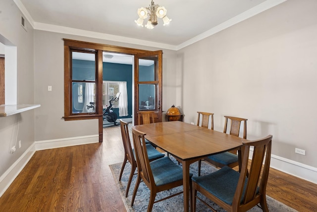 dining space with baseboards, wood finished floors, and a notable chandelier