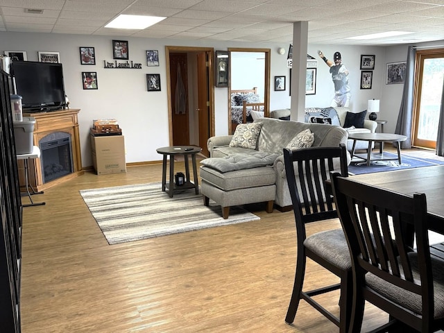 25-14 Country Hill Ct, Lake Carroll, IL 61046 - living room with light wood-style flooring, a fireplace, a paneled ceiling, visible vents, and baseboards