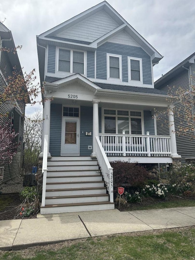 view of front facade with a porch, central AC, and stairs