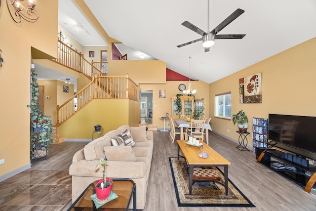 living area featuring wood finished floors, stairway, high vaulted ceiling, baseboards, and ceiling fan with notable chandelier