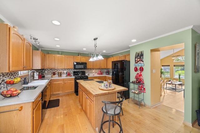 kitchen with decorative backsplash, butcher block counters, a kitchen island, a sink, and black appliances