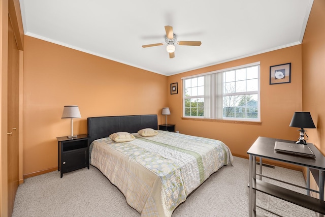 bedroom featuring a ceiling fan, baseboards, ornamental molding, and light carpet