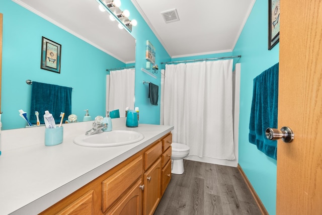 bathroom featuring visible vents, crown molding, vanity, wood finished floors, and toilet