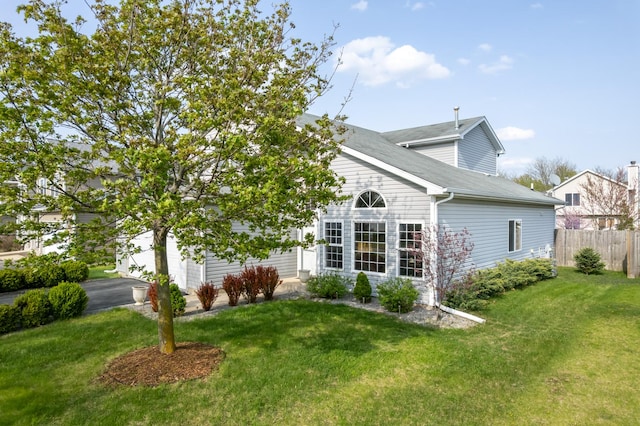 back of property featuring a lawn and fence