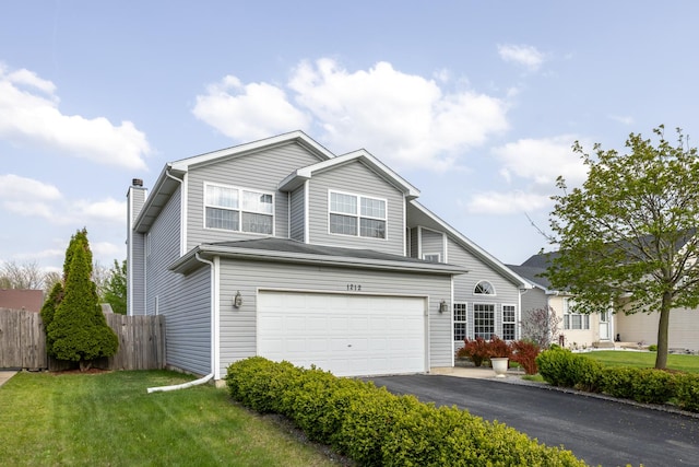 traditional-style house with a front lawn, aphalt driveway, fence, a chimney, and an attached garage