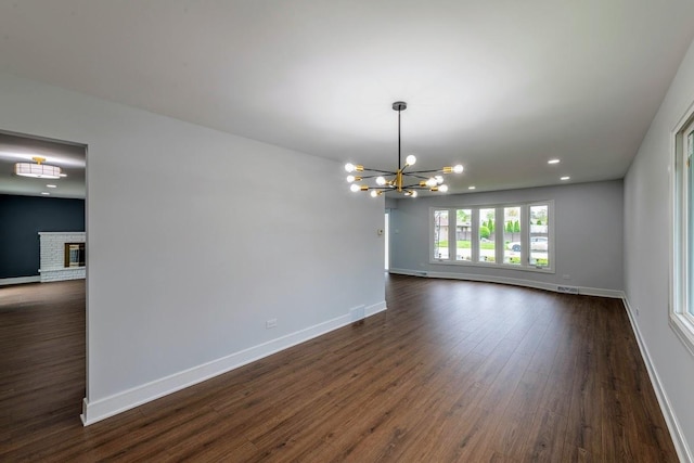 612 Thornwood Dr, South Holland, IL 60473 - unfurnished dining area with dark wood-style flooring, an inviting chandelier, a fireplace, recessed lighting, and baseboards
